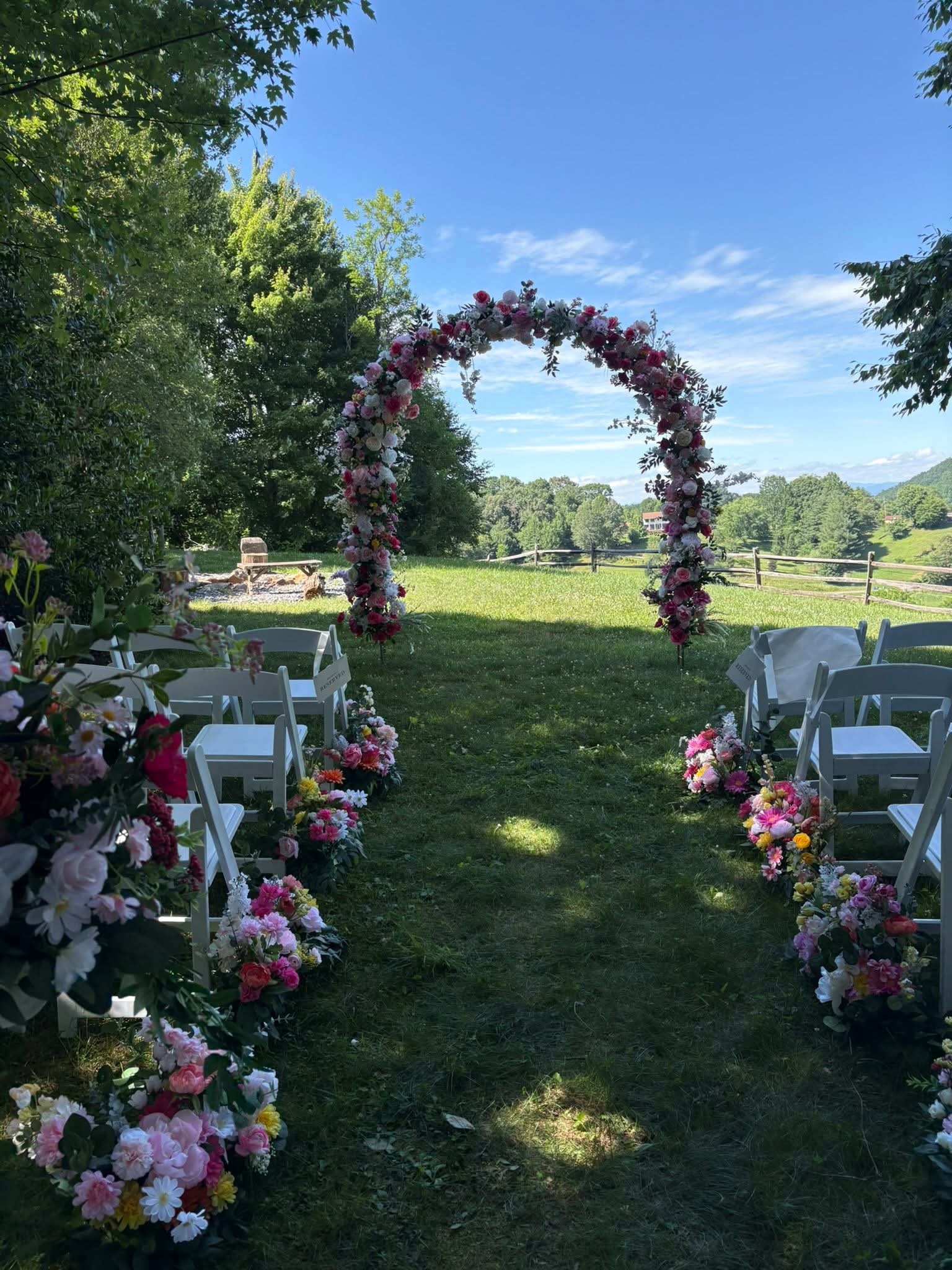 Outdoor wedding ceremony with full floral arch